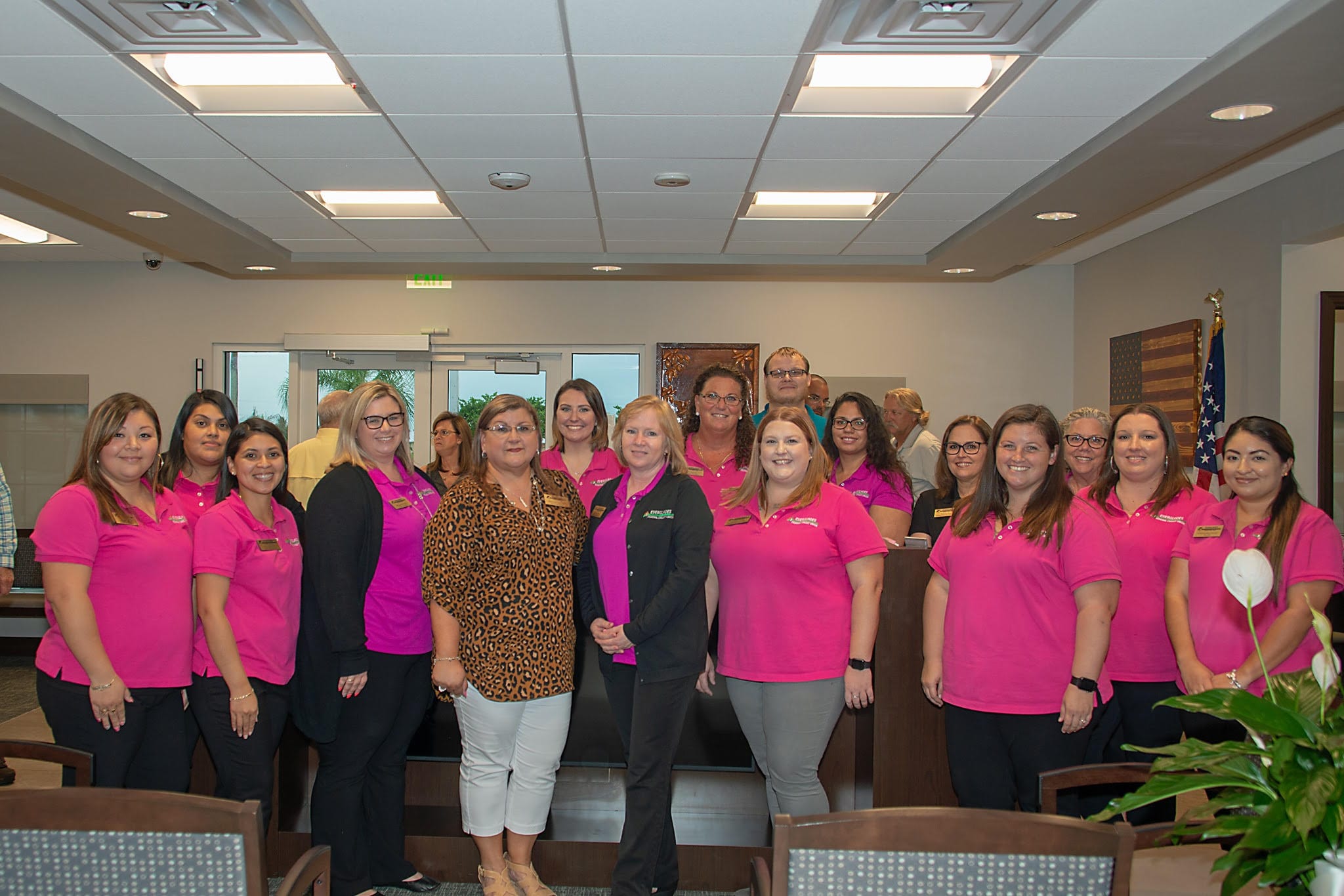 Staff of Everglades Federal Credit Union wearing pink shirts and smiling in a group